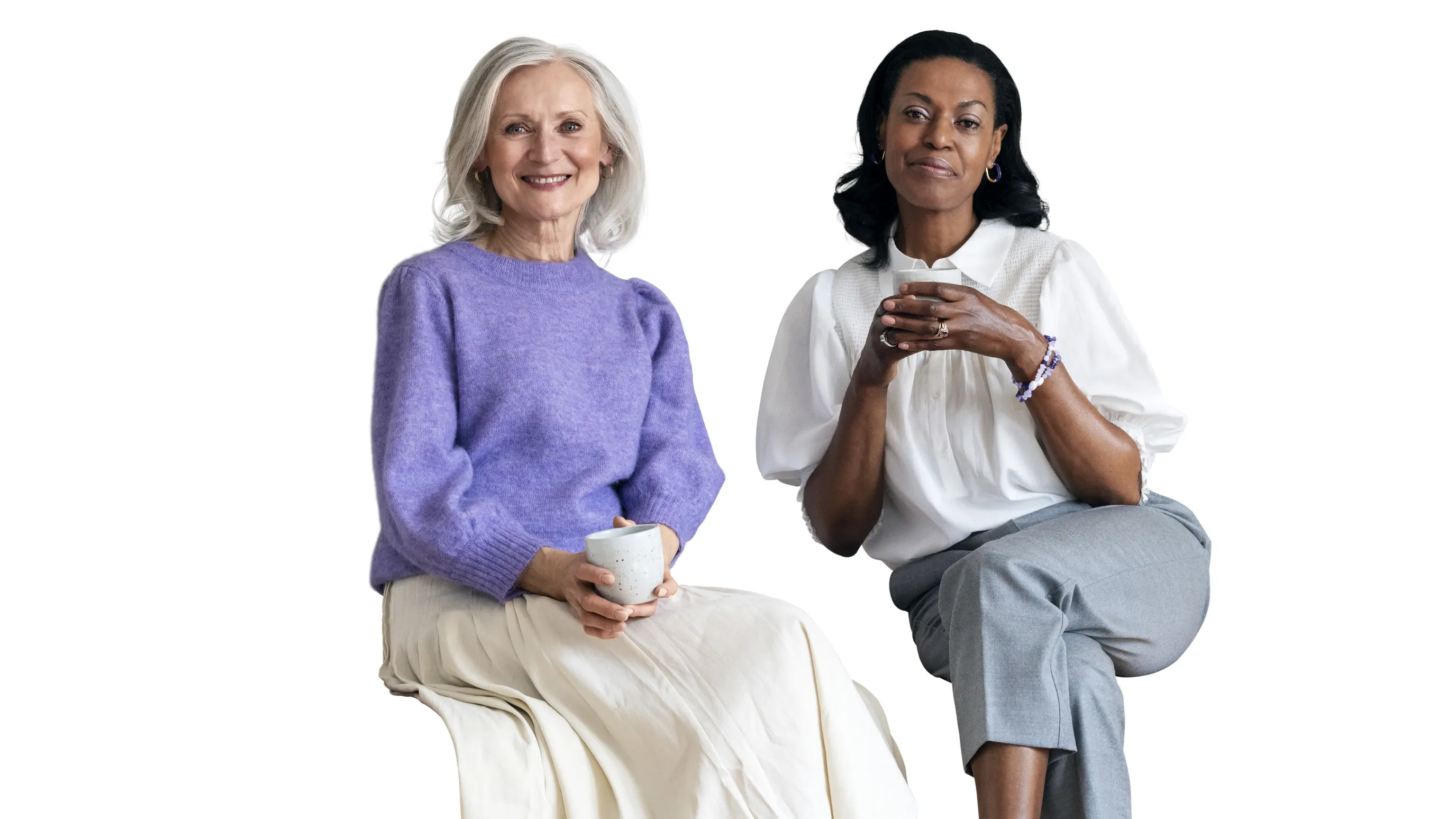 Two friends enjoying a cup of coffee wearing hearing aids