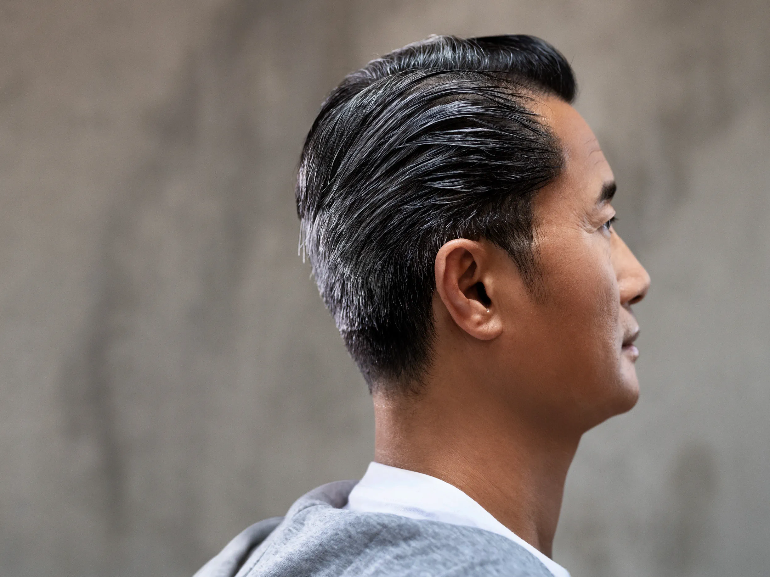 Wearing  nearly invisible hearing aids behind the ear